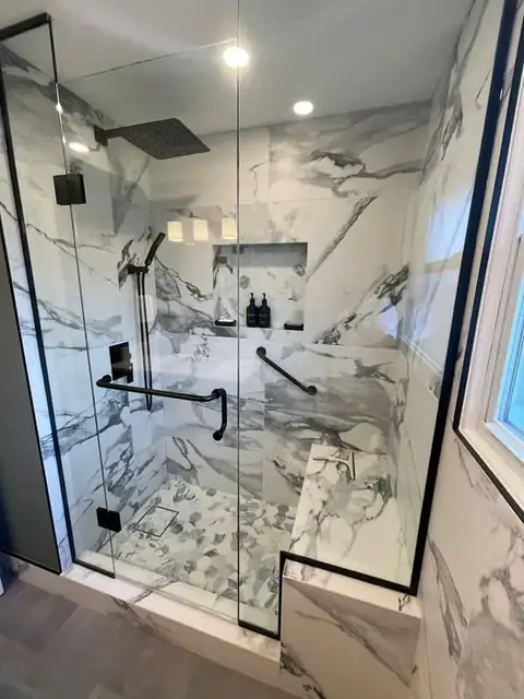 Marble-look walk-in shower with a bench and black fixtures