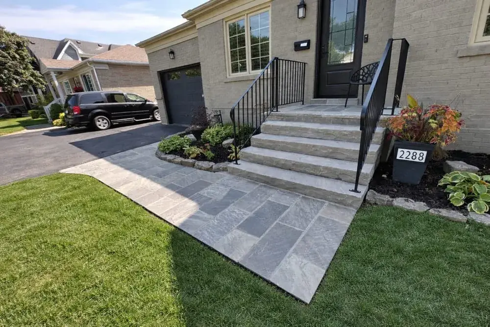 Large flagstone walkway and steps with a black iron railing