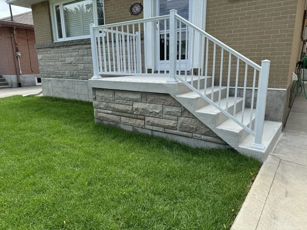 Stone clad porch and stairs with a white aluminum railing