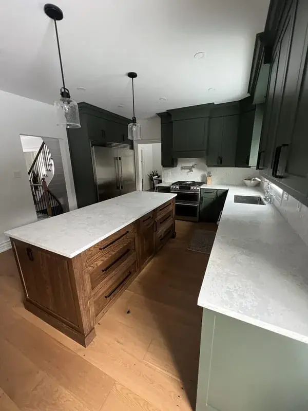 The same green kitchen, island and stair view